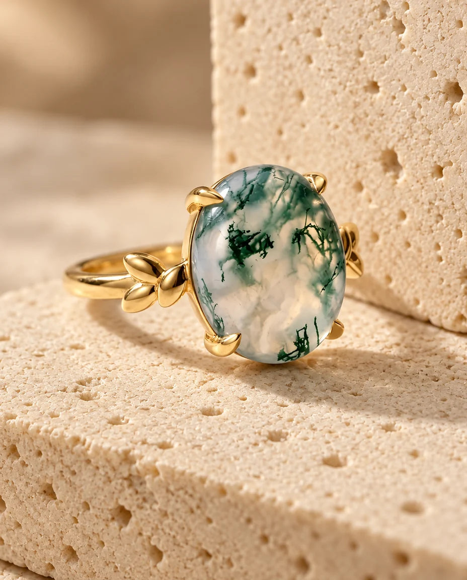 Anello Agata Muschiata Ovale 10x12 mm in Argento 925 Placcato Oro - esposto su un blocco di travertino