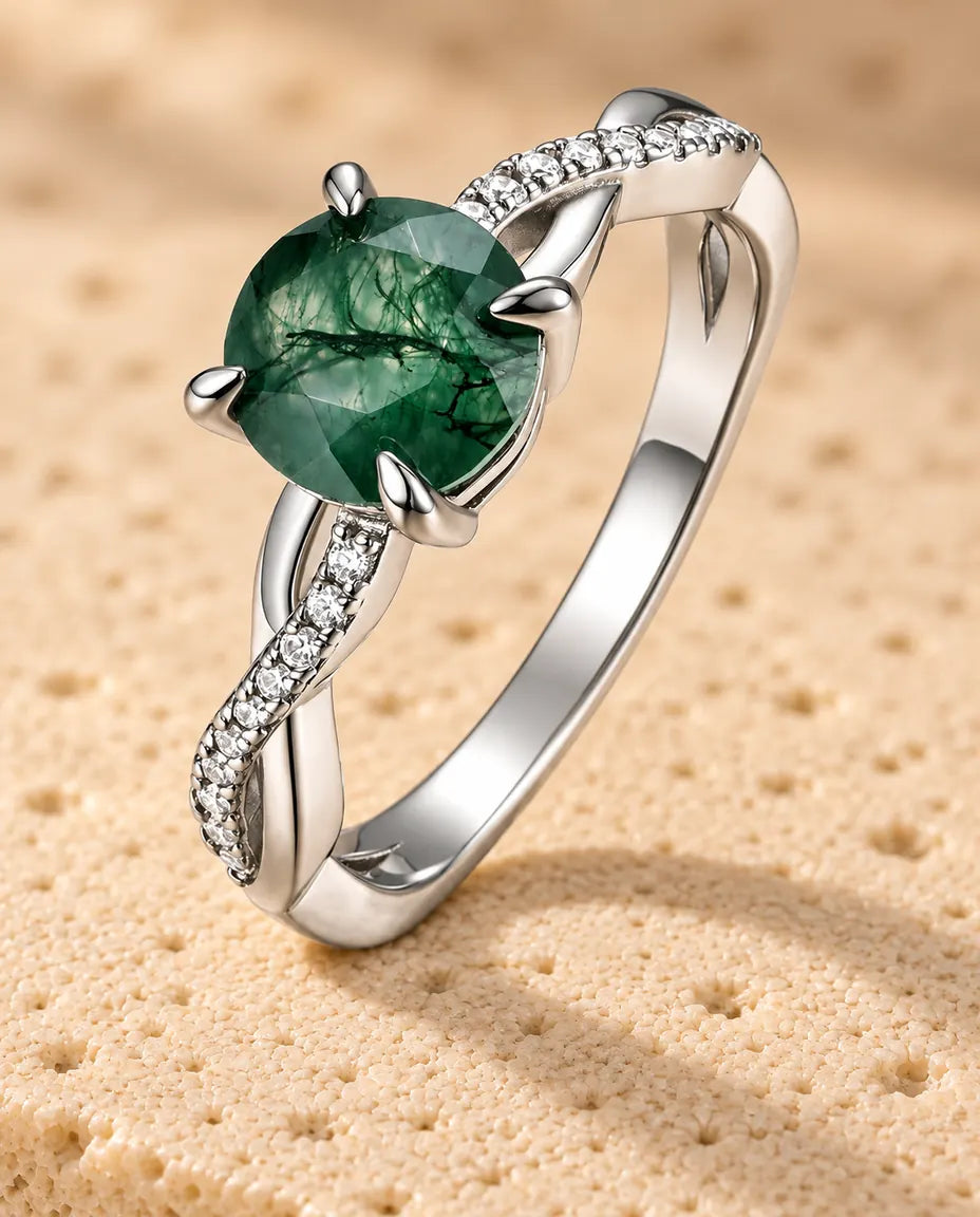 Anello Agata Muschiata Tonda Sfaccettata - in piedi su una superficie chiara ruvida