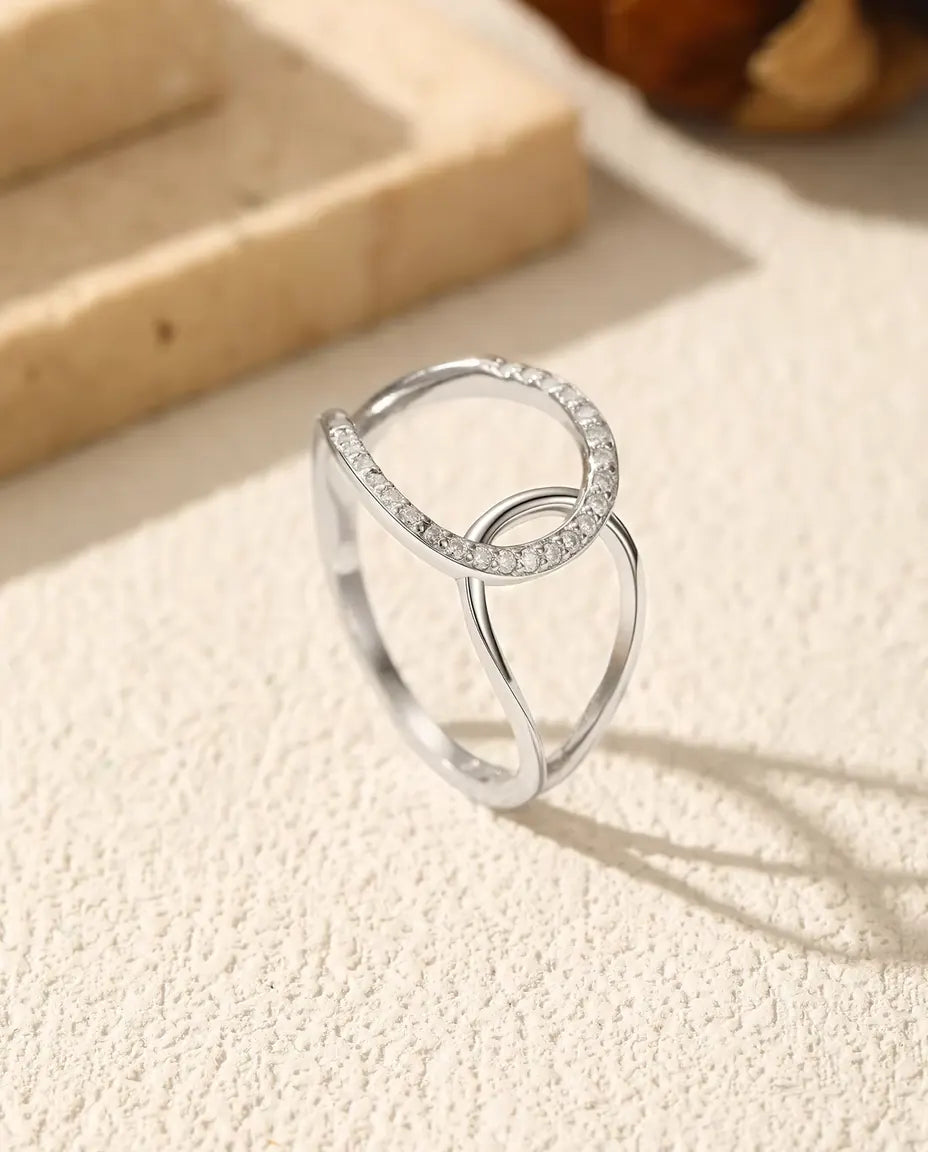 Anello con Cerchi Intrecciati in Argento 925 - in piedi su una superficie chiara ruvida