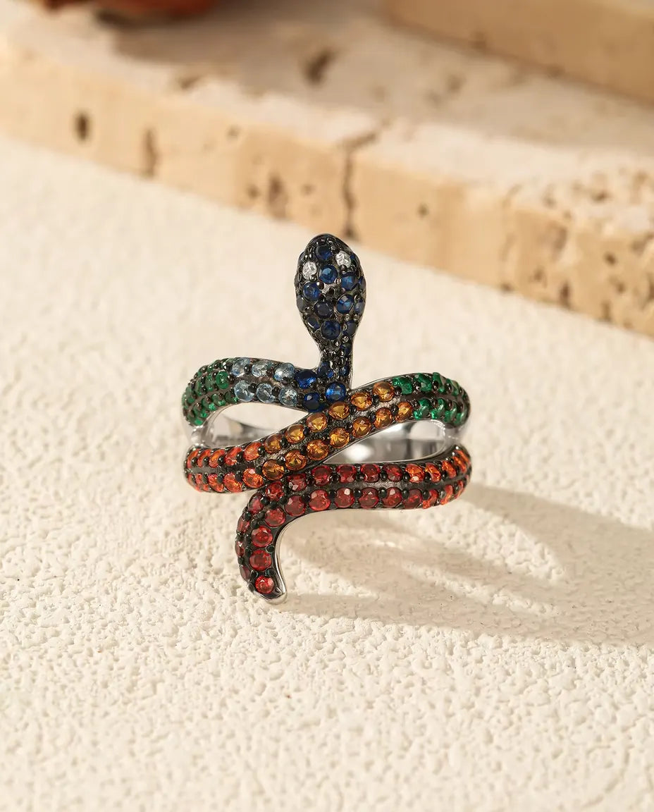 Anello Serpente in Argento 925 con Pietre Arcobaleno - in piedi su una superficie chiara ruvida