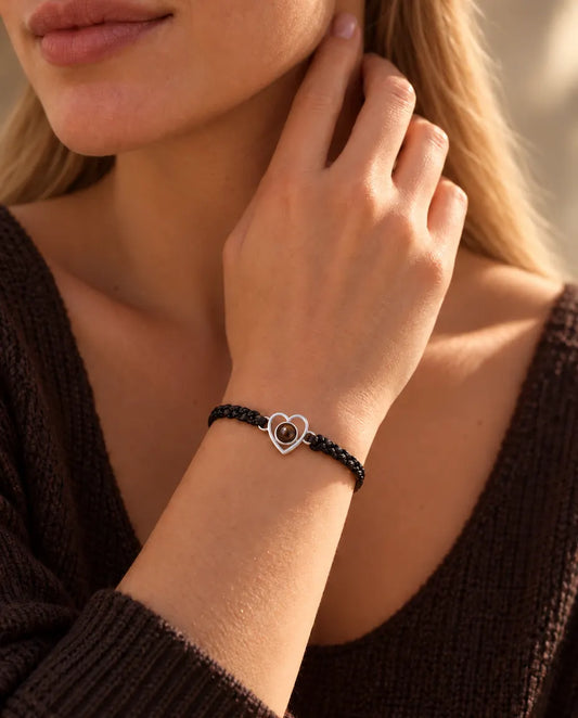Donna con le dita sul lato del collo che indossa il bracciale con cuore aperto in argento su cordino nero