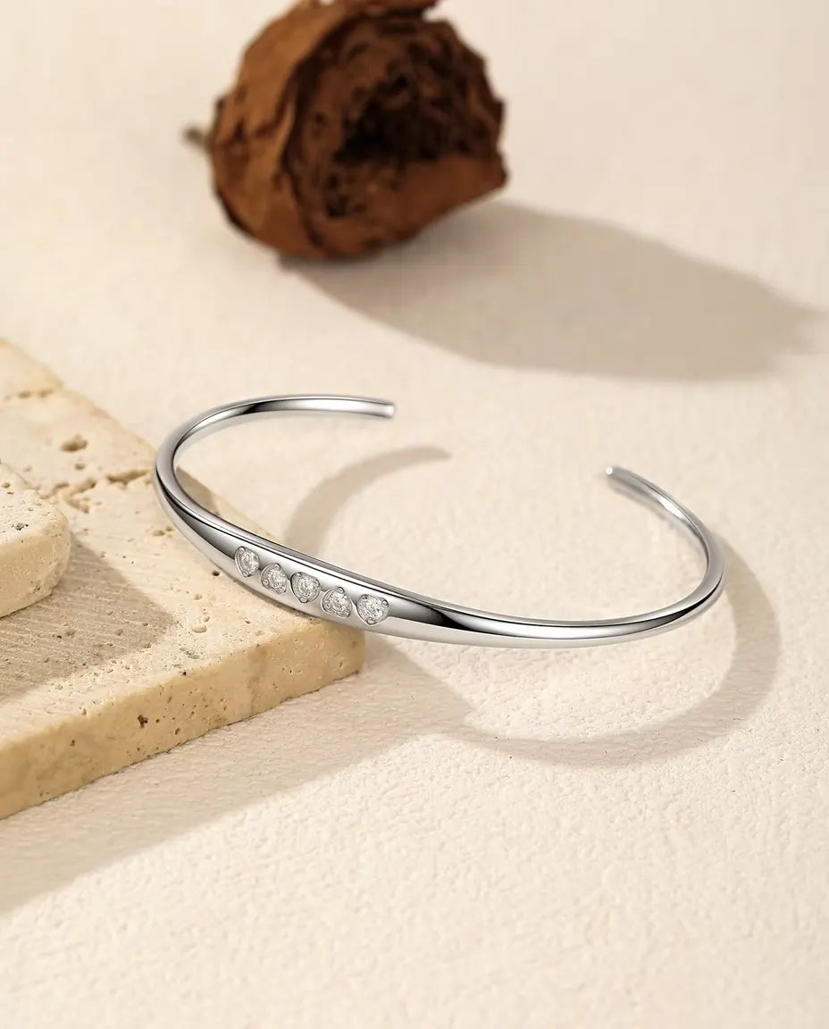 Bracciale Rigido Moissanite in Argento 925 - adagiato su una lastra di travertino