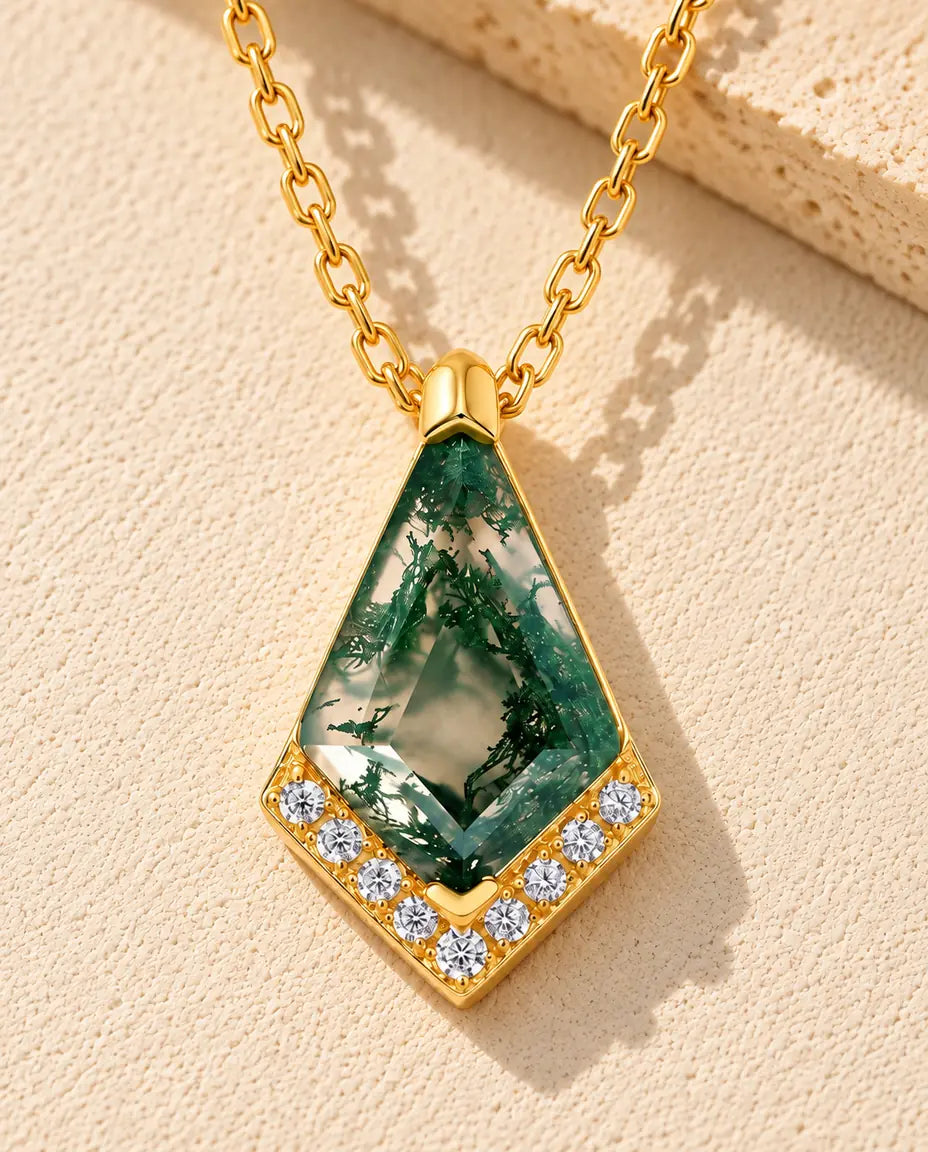 Collana Agata Muschiata in Argento 925 Placcato Oro - appoggiata su una superficie chiara ruvida accanto a un blocco di travertino