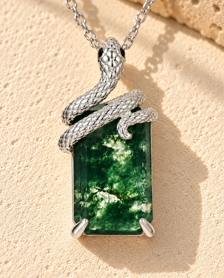 Collana Agata Muschiata Serpente in Argento 925 - appoggiata su una superficie chiara ruvida accanto a un blocco di travertino