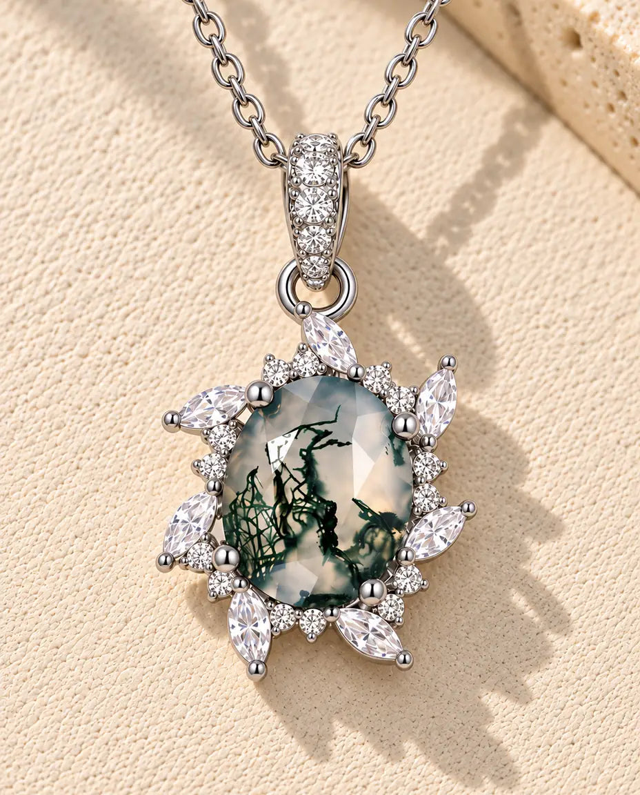 Collana Agata Muschiata Sole in Argento 925 - appoggiata su una superficie chiara ruvida accanto a un blocco di travertino