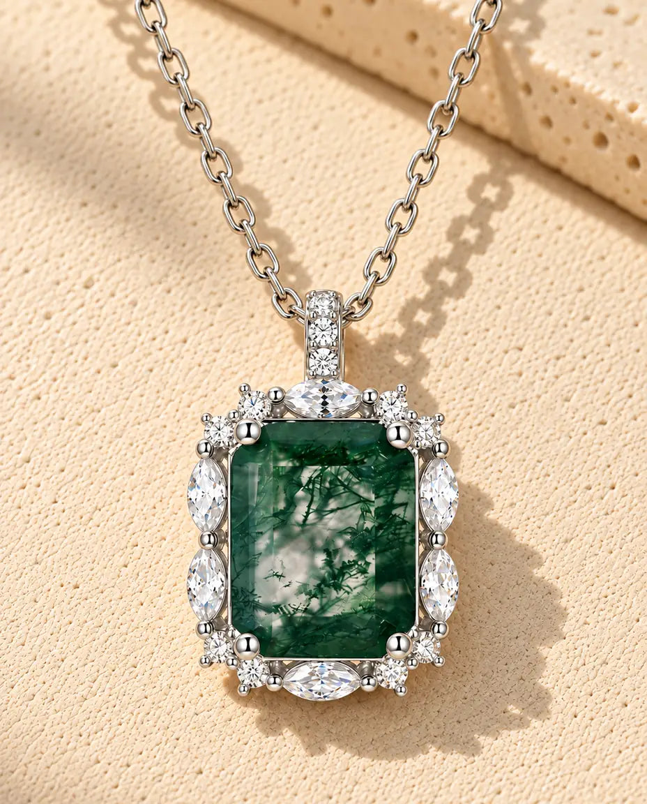 Collana Agata Muschiata Taglio Smeraldo in Argento 925 - appoggiata su una superficie chiara ruvida accanto a un blocco di travertino