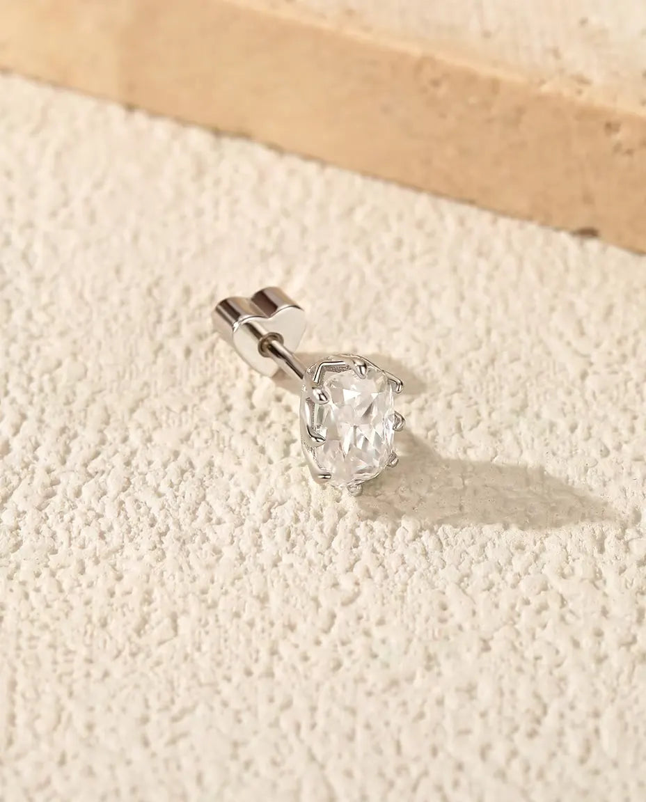 Orecchini con Moissanite Taglio Radiant 4 x 6 mm in Argento 925 - su una superficie chiara ruvida accanto a una lastra di travertino