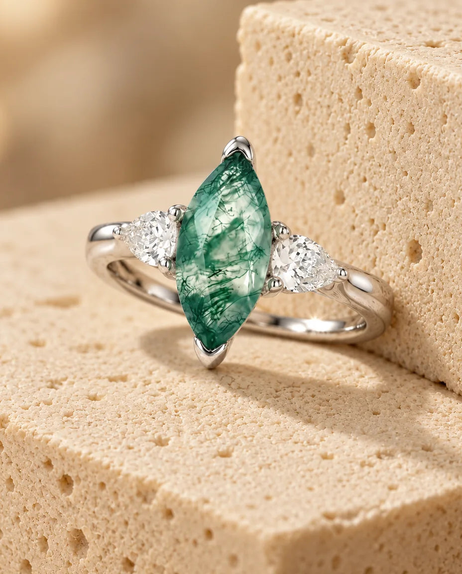 Anello Agata Muschiata Marquise 5x10 mm - esposto su un blocco di travertino
