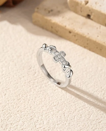 Anello Croce Moissanite in Argento 925 - in piedi accanto a blocchi di travertino, inquadratura più ampia