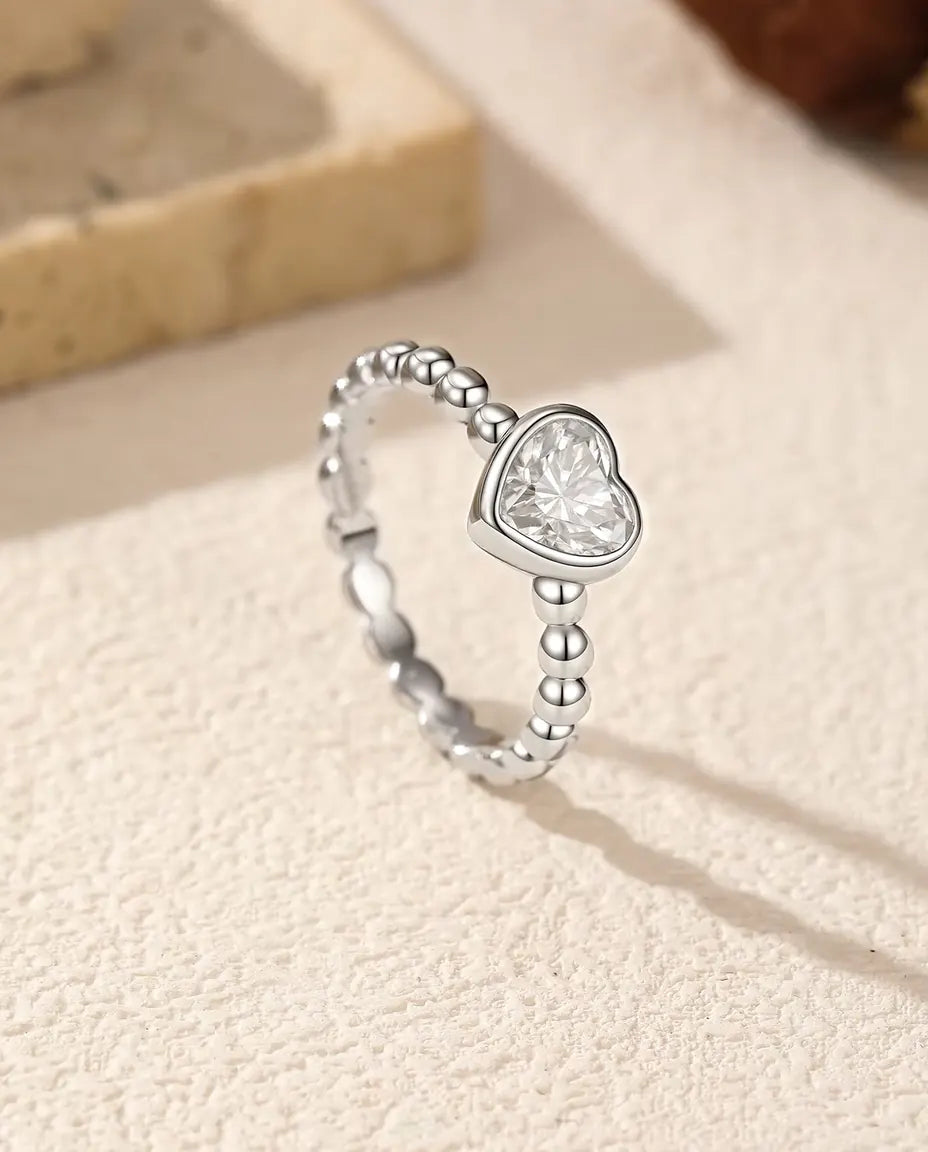 Anello Cuore Moissanite in Argento 925 - in piedi su una superficie chiara ruvida