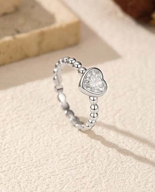 Anello Cuore Moissanite in Argento 925 - in piedi su una superficie chiara ruvida