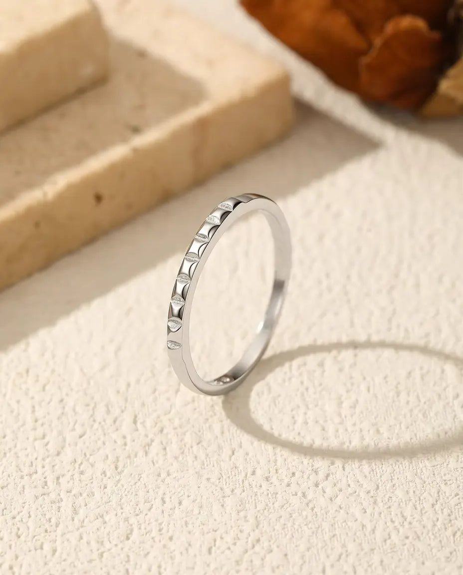 Anello Impilabile con Borchie in Argento 925 - in piedi su una superficie chiara ruvida