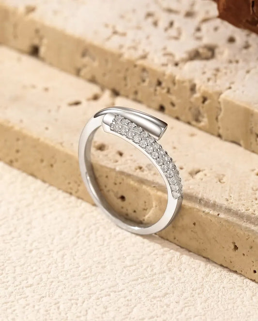Anello Moissanite Aperto Incrociato in Argento 925 - appoggiato sul bordo di una lastra di travertino