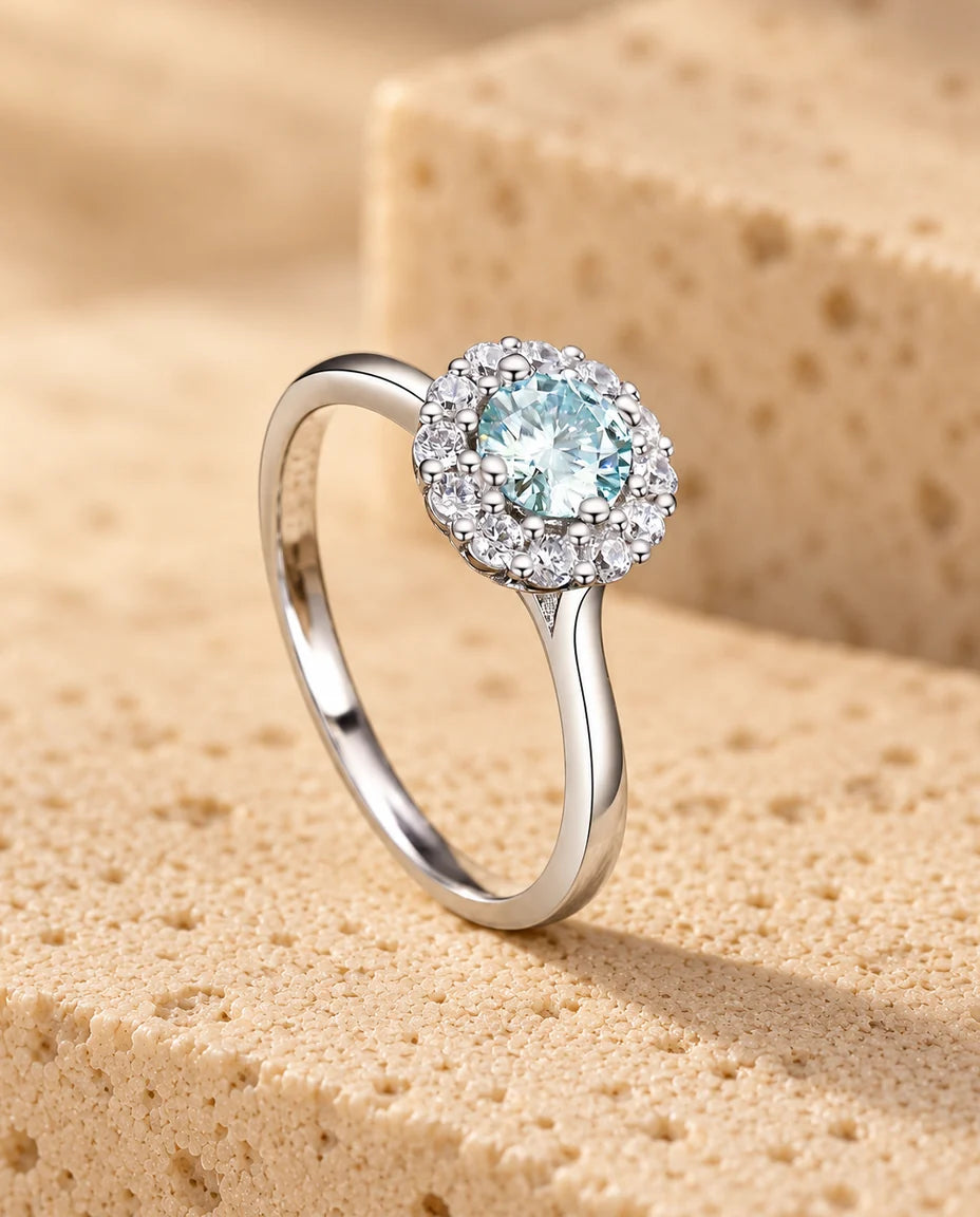 Anello Moissanite Halo Verde Ottanio 0 - esposto su un blocco di travertino
