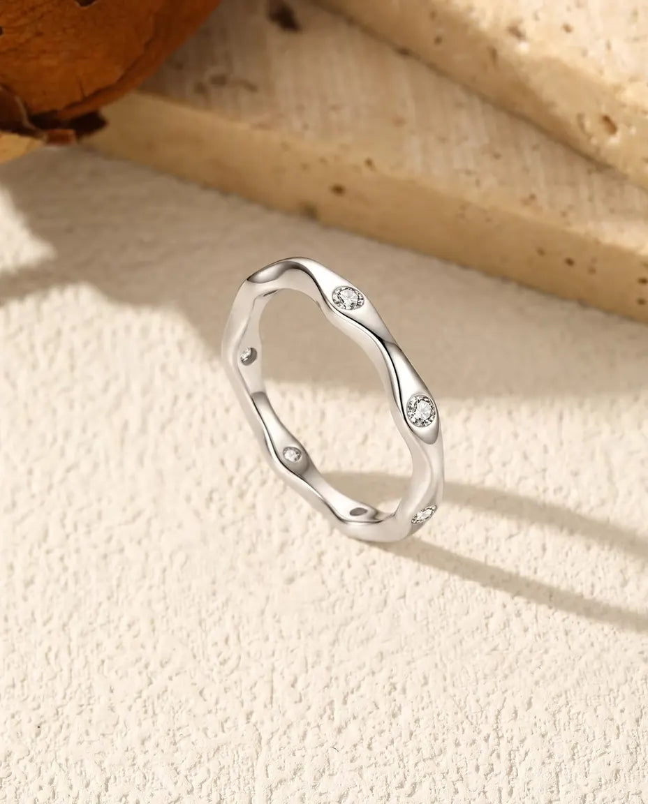 Anello Moissanite Onda in Argento 925 - in piedi su una superficie chiara ruvida