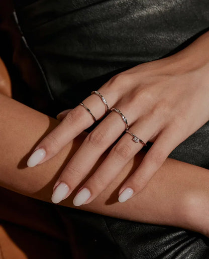 Anello Moissanite Onda in Argento 925 - indossato insieme ad altri anelli, mani una sull’altra