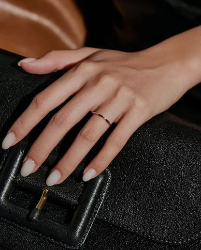 Anello Onda in Argento 925 - indossato su una mano appoggiata su una borsa nera