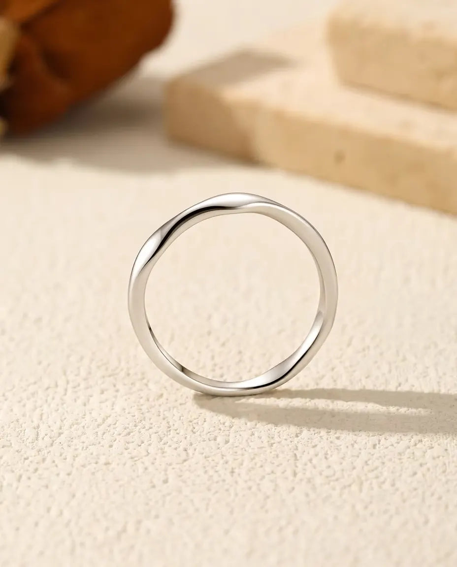 Anello Onda in Argento 925 - visto di fronte, in piedi su una superficie chiara ruvida