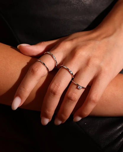 Anello Onda in Argento 925 - indossato insieme ad altri anelli, primo piano delle dita