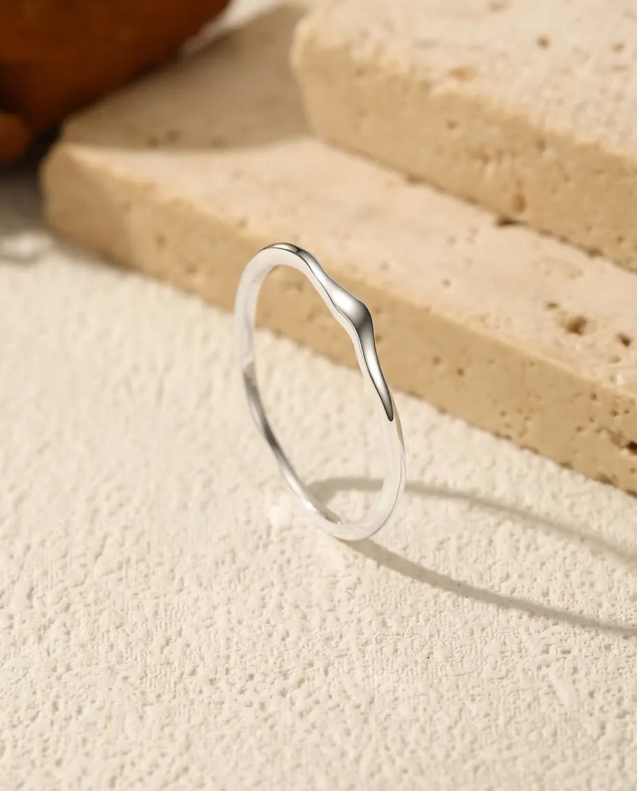 Anello Ondulato Impilabile in Argento 925 - in piedi su una superficie chiara ruvida