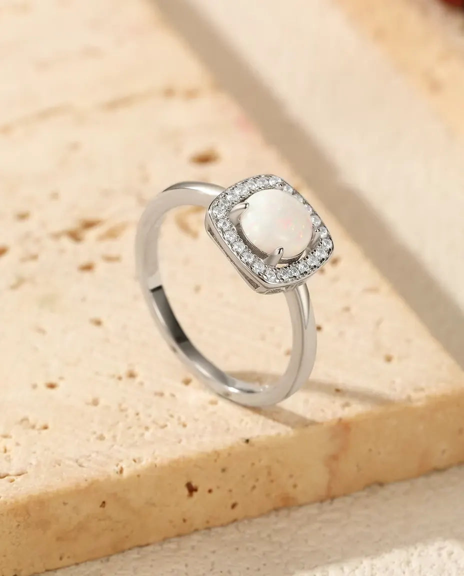 Anello Opale con Halo in Argento 925 - appoggiato sul bordo di una lastra di travertino