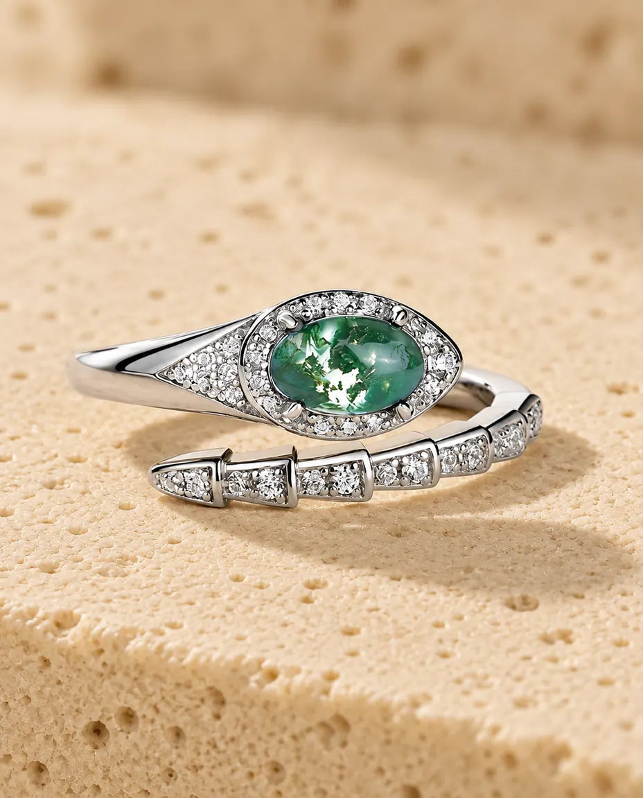 Anello Serpente Agata Muschiata in Argento 925 - appoggiato in piano su una superficie chiara ruvida