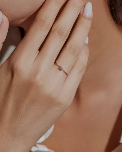 Anello Solitario Moissanite Sottile in Argento 925 - indossato da una modella con le mani vicino al viso