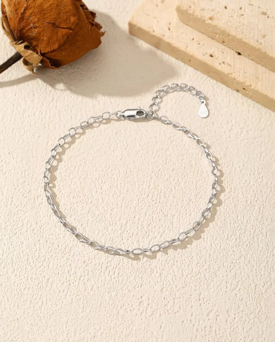 Bracciale Catena Forzatina in Argento 925 - disteso su una superficie chiara ruvida, con chiusura e prolunga