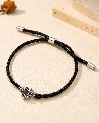 Bracciale con foto dentro personalizzato, cuore argentato con ali d'angelo su cordino nero ritorto, su gesso color crema