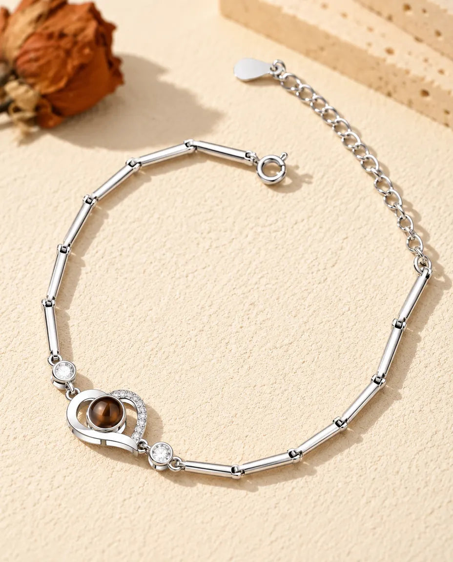 Bracciale con foto dentro argentato con cuore aperto su catena sottile a barrette, sul gesso crema