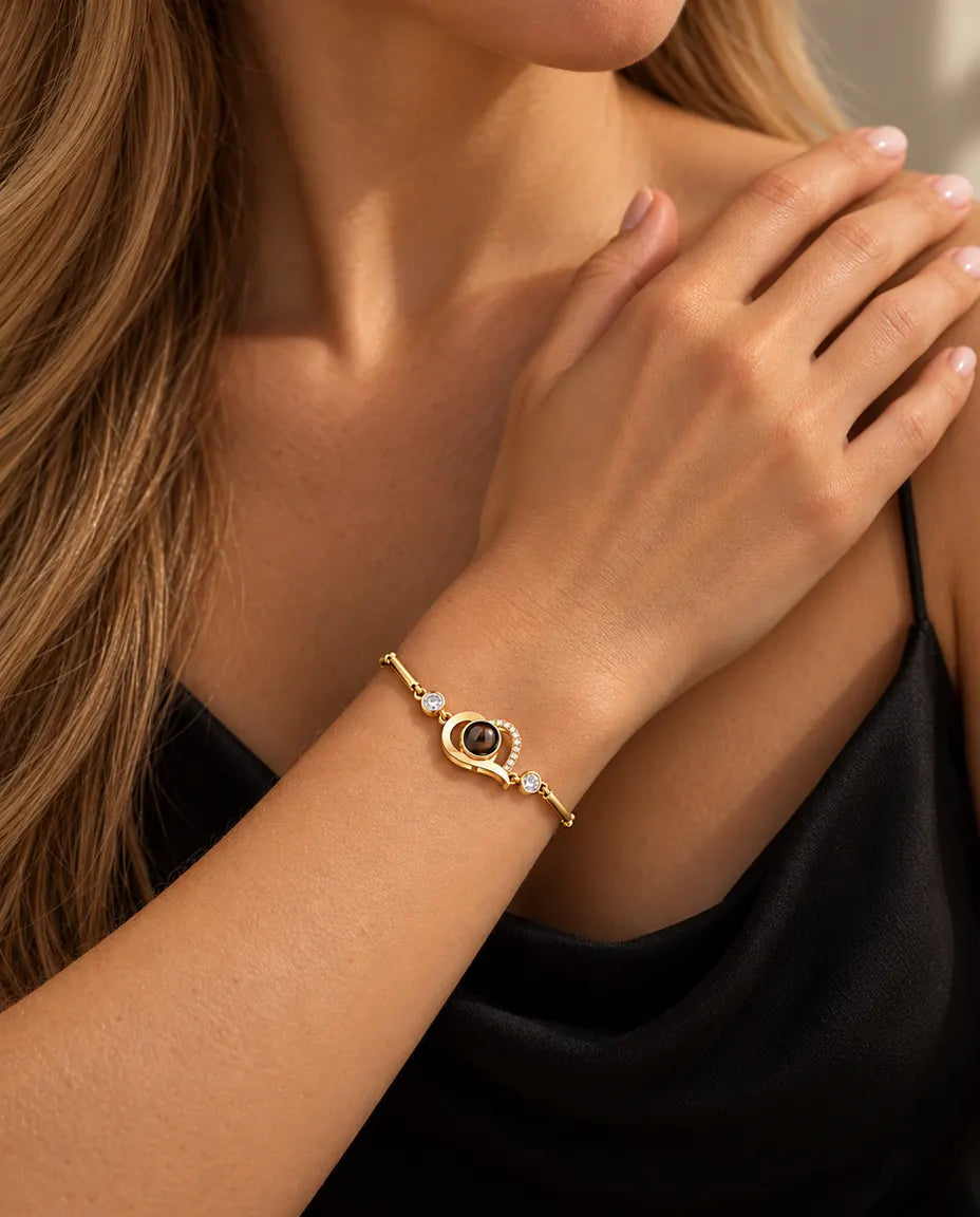 Primo piano del bracciale dorato con cuore aperto e zirconi al polso, vicino alla clavicola