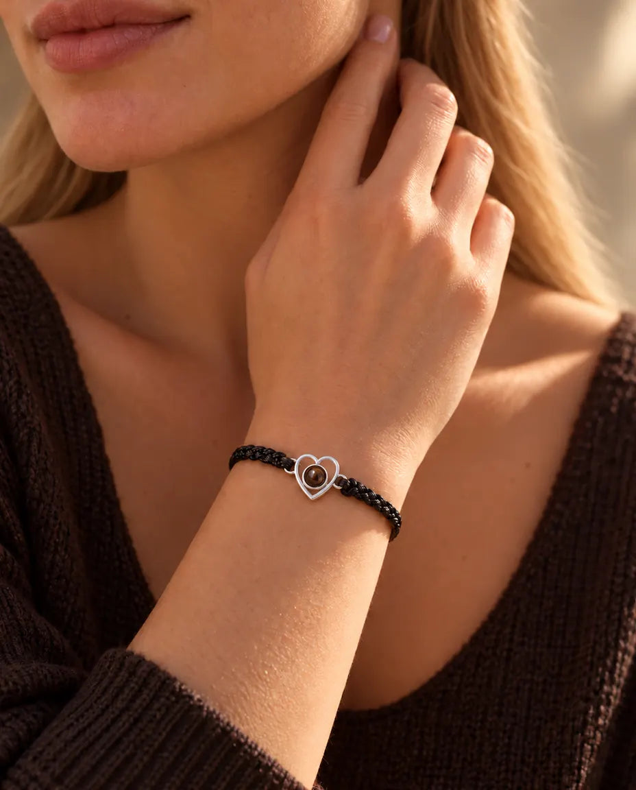 Donna con le dita sul lato del collo che indossa il bracciale con cuore aperto in argento su cordino nero