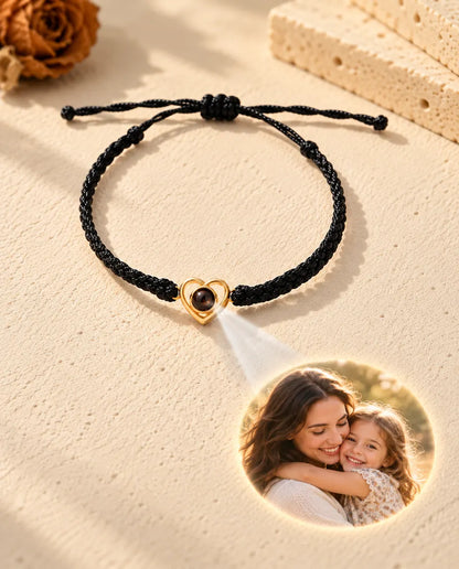 La luce attraverso la pietra marrone del cuore aperto dorato proietta sul gesso una foto di mamma e figlia
