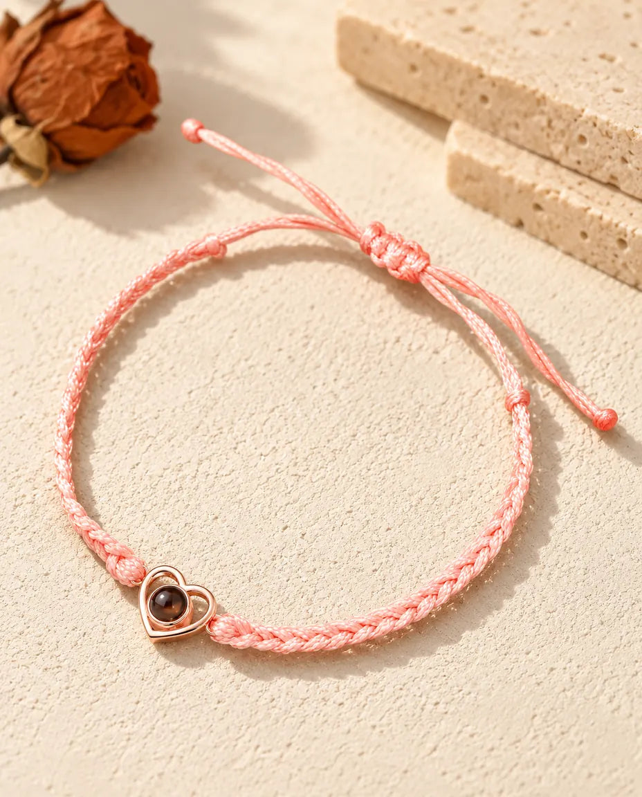Cuore aperto color oro rosa su cordino intrecciato rosa con nodo scorrevole regolabile