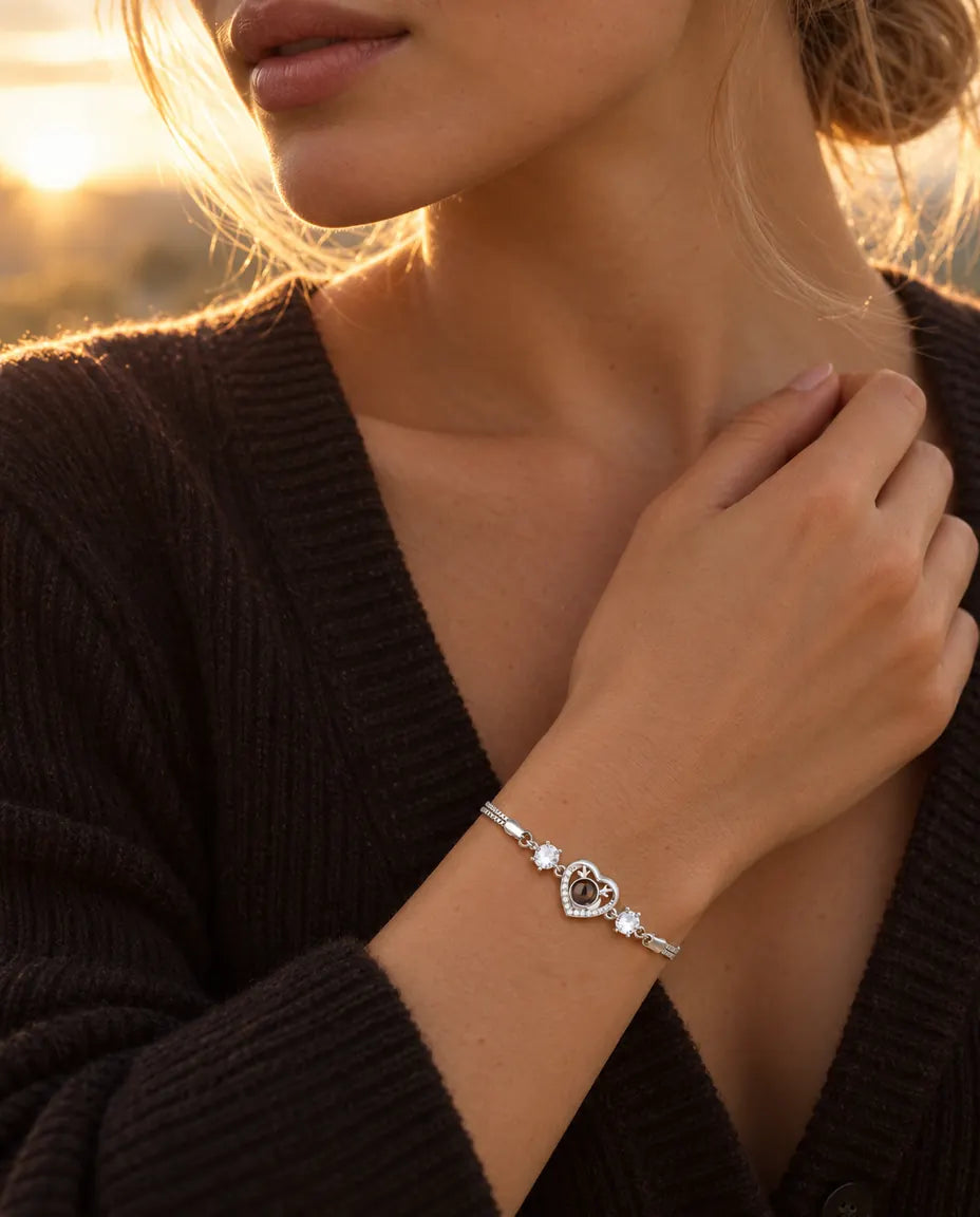 Donna che sfiora lo scollo del maglione scuro e indossa il bracciale con cuore argentato e corna di cervo