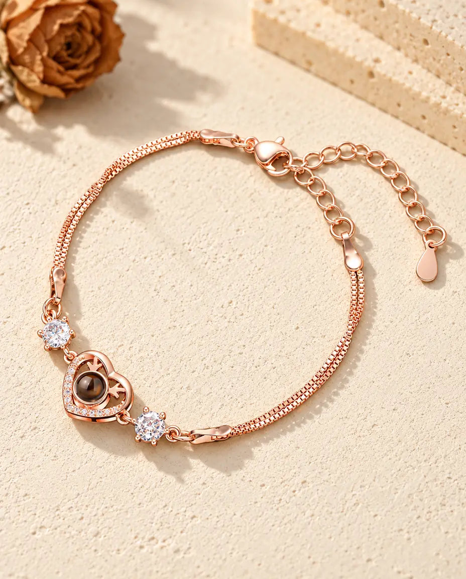 Bracciale color oro rosa con cuore e corna di cervo, pietre laterali brillanti e doppia catena veneziana