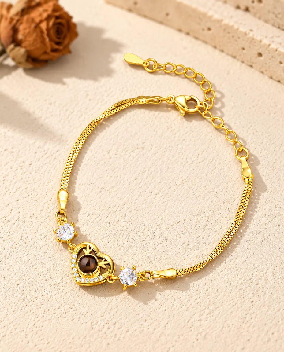 Bracciale dorato con charm a cuore e zirconi, chiusura a moschettone e catenella di estensione