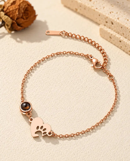 Bracciale color oro rosa con cuore a impronta di zampa, pietra rotonda e chiusura a moschettone