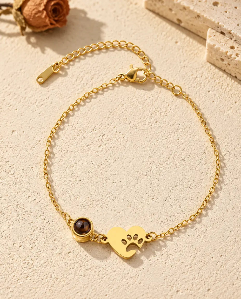 Vista dall'alto del bracciale con foto dentro dorato con cuore e impronta di zampa