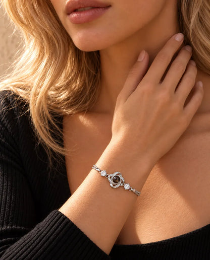 Donna che si sfiora il collo e indossa il bracciale argentato con nodo d'amore e foto dentro
