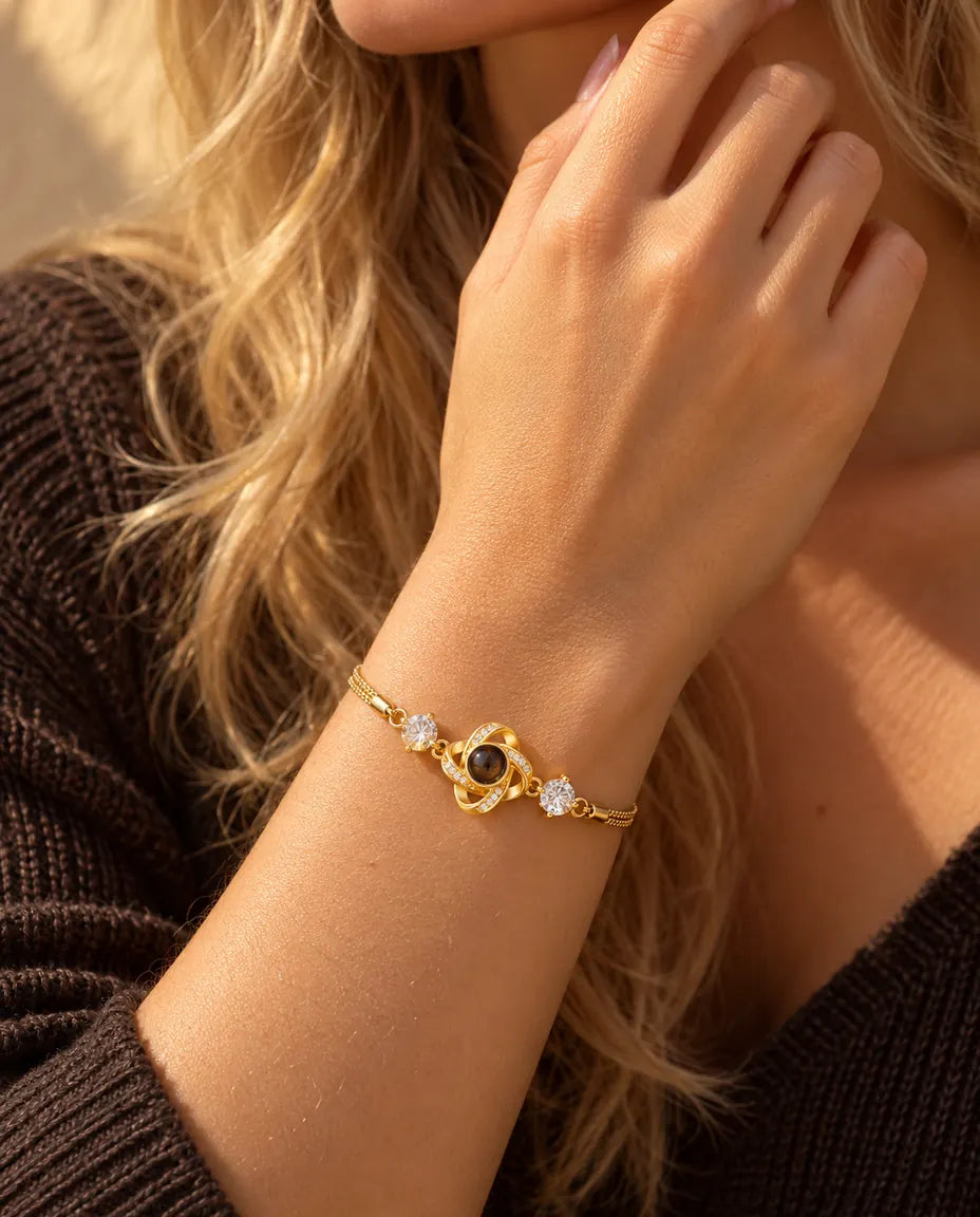 Primo piano del bracciale dorato con nodo d'amore e zirconi al polso, vicino alla mascella
