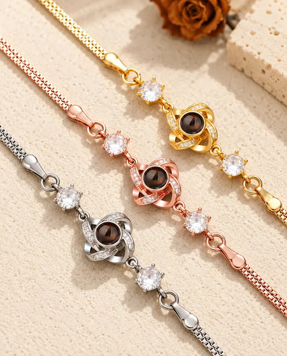 Primo piano di tre charm a nodo d'amore con zirconi a pavé, uno per ogni colore