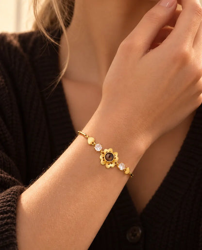 Primo piano del bracciale dorato con quadrifoglio e cuoricini al polso, vicino alla mascella
