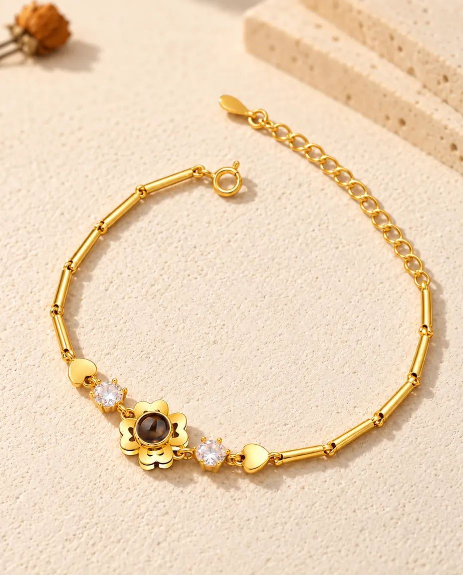 Bracciale dorato con quadrifoglio a petali di cuore, chiusura ad anello a molla e prolunga
