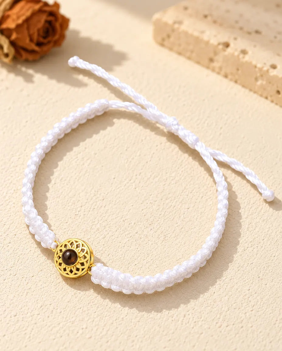 Bracciale con foto dentro su cordino intrecciato bianco, con charm tondo dorato e chiusura a nodo scorrevole