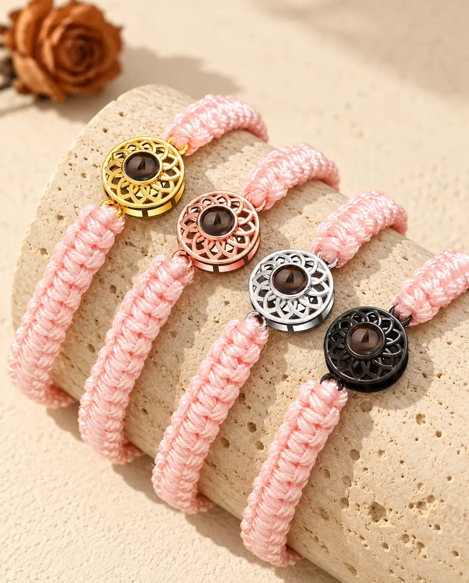 Bracciali con cordino intrecciato rosa e charm tondi in quattro colori: dorato, color oro rosa, argentato e nero