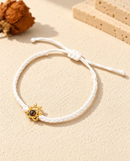 Bracciale con foto dentro su cordino intrecciato bianco con charm a zampa dorato e nodo scorrevole