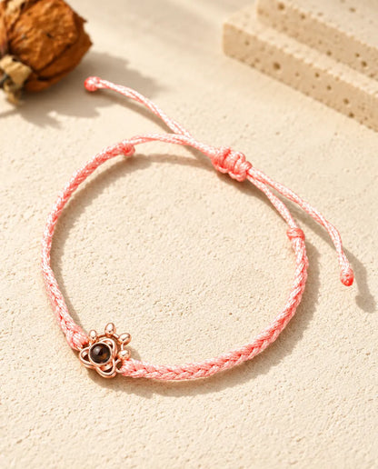 Charm a zampa color oro rosa su cordino intrecciato rosa con nodo scorrevole regolabile