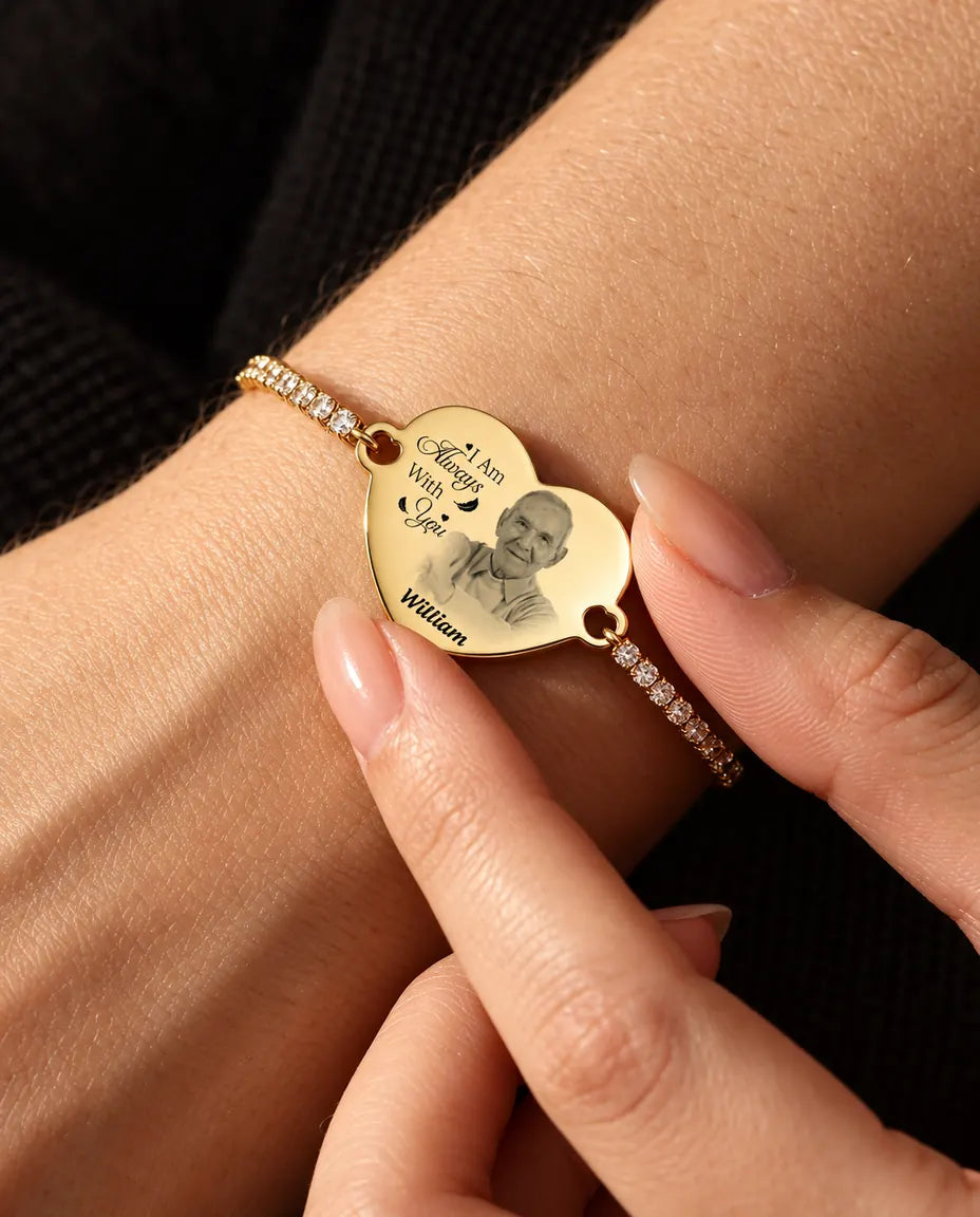 Punta delle dita che tengono sul polso il cuore dorato con foto incisa del bracciale