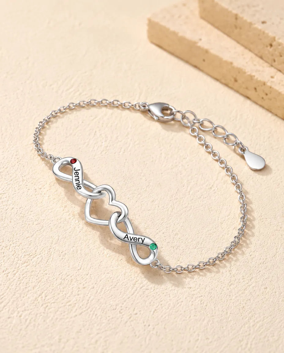 Bracciale Infinito Personalizzato 2 Nomi - due nodi infiniti attorno a un cuore e due pietre portafortuna - vista di tre quarti